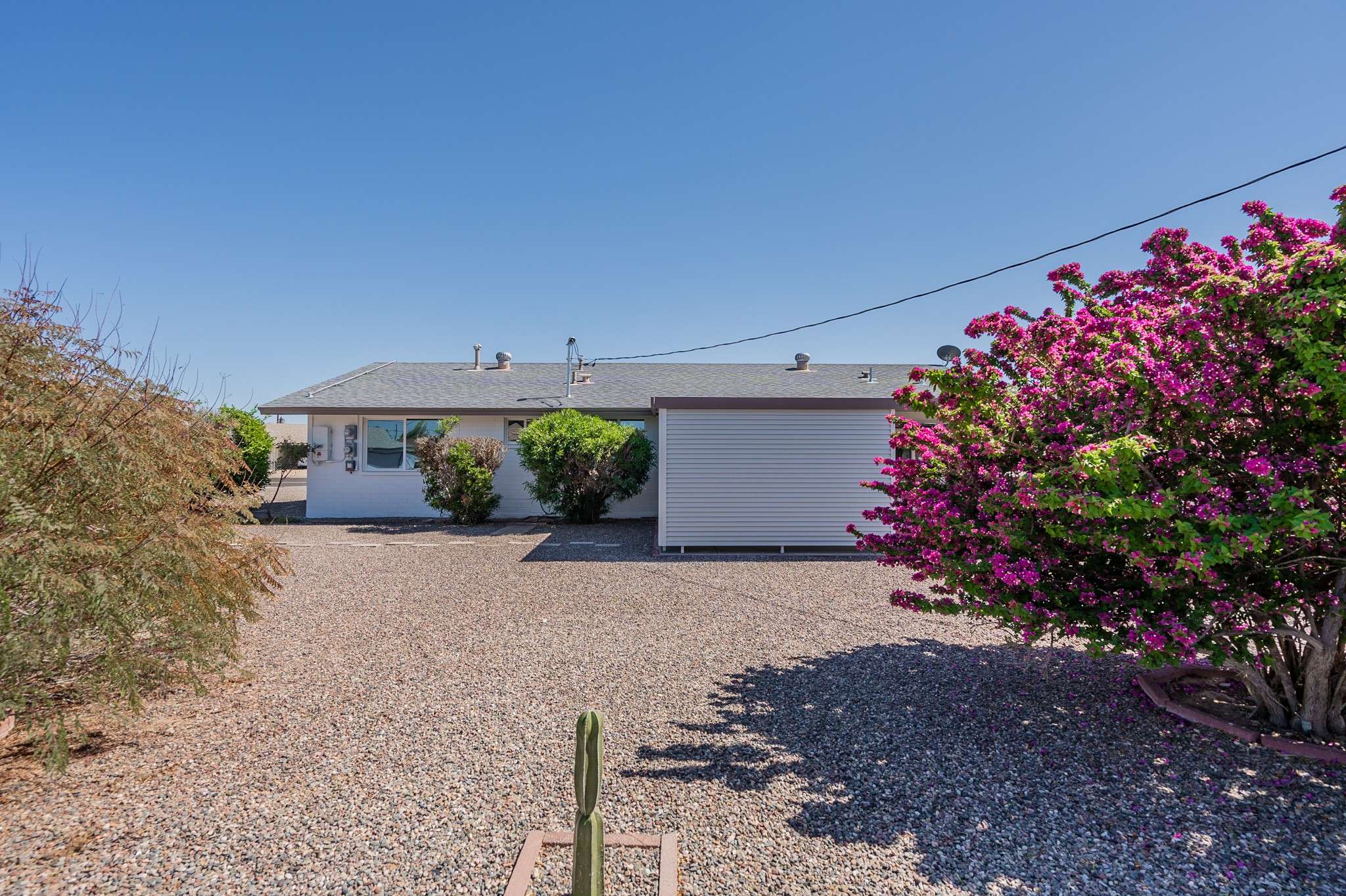 31 of 35. This spacious backyard offers a serene desert landscape with low-maintenance gravel and mature shrubs. The open layout provides plenty of potential for adding a patio, garden, or outdoor entertaining space in a peaceful Arizona setting.