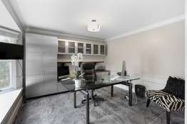 Private home office / study, with large bay window and custom stainless steel cabinetry.