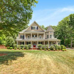 Lovely custom-built Victorian home situated on over an acre with an oversized wrap around covered porch!