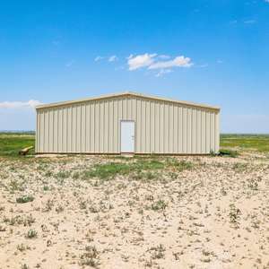 Rural 40.46 acre level parcel with sweeping views and a 4800 sf outbuilding located in Avonsdale, CO.