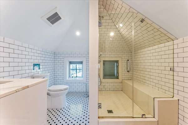 Larger bathroom with long shower and bench seating