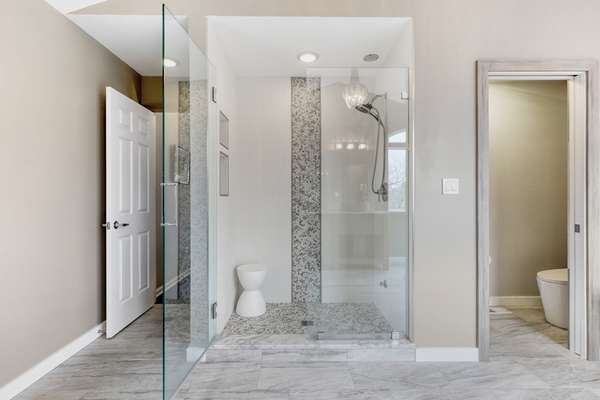 Stand-alone, multi head, custom tiled, walk-in shower.