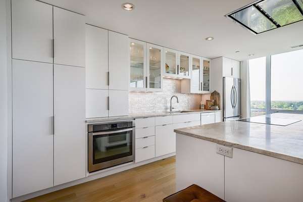 White Cabinetry, Solid Surface Countertops, and Induction Cooktop
