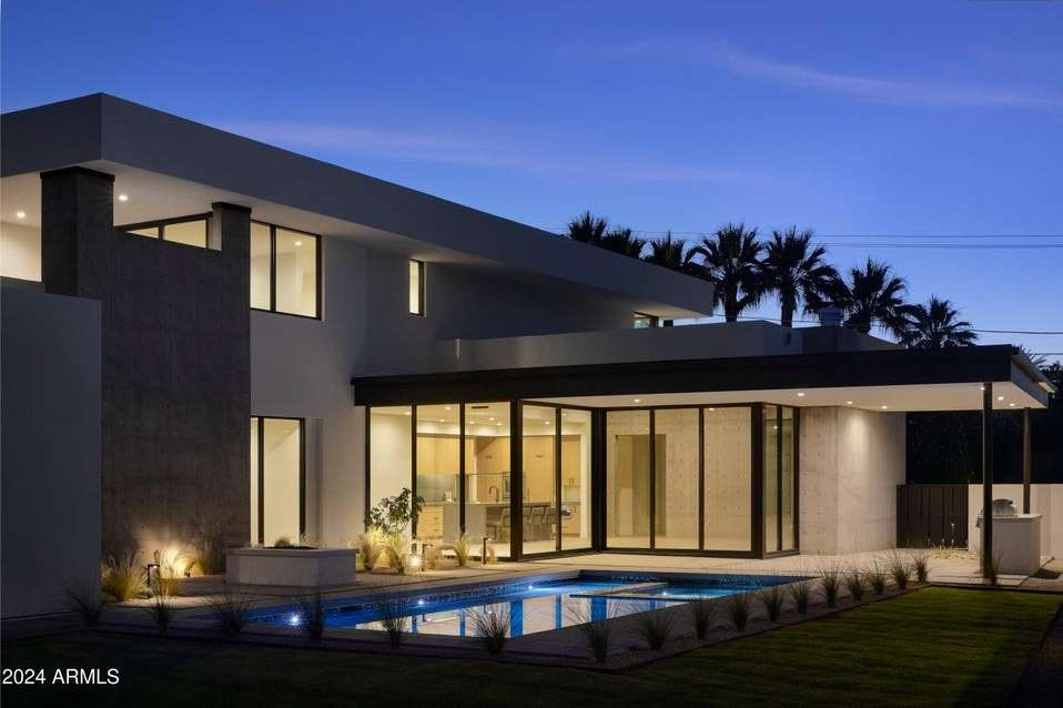 11 of 27. This evening view highlights the home s sleek pool and covered patio, enhanced by ambient lighting and minimalist landscaping perfect for refined outdoor living in Phoenix s coveted Arcadia area.