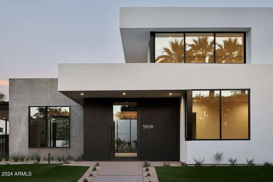 2 of 27. A clean-lined entryway welcomes you into this luxury Phoenix residence. With high-contrast details and statement architecture, it exemplifies desert-modern elegance near Arizona Country Club.