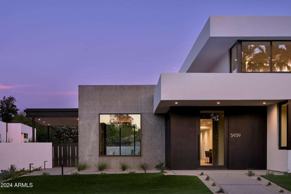4 of 27. Twilight sets the stage for this showpiece home s striking silhouette. The crisp geometry and warm interior light evoke a private, modern sanctuary in one of Phoenix s most desirable pockets.