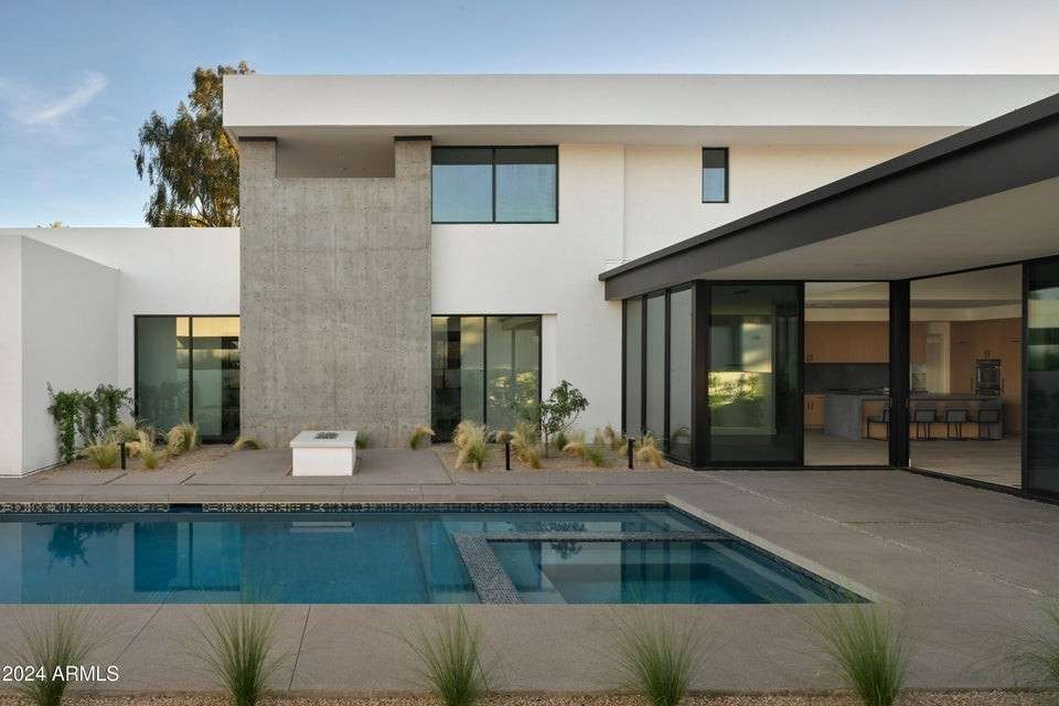 6 of 27. Enjoy seamless indoor-outdoor living with this elegant poolscape. Framed by minimalist landscaping and full-height glass, this space offers a modern twist on desert resort vibes.