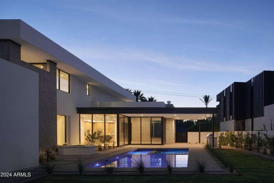 9 of 27. The backyard comes alive at dusk, with soft lighting highlighting the pool s clean geometry. A picture-perfect setting for gatherings, relaxation, or luxury under the stars.