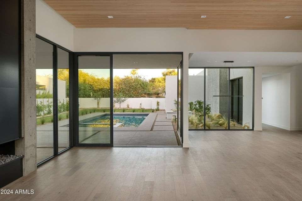 10 of 27. Wall-to-wall glass and natural wood accents make this main living space a showcase of light and flow. Overlooking the pool, it s the heart of indoor-outdoor living in Phoenix.