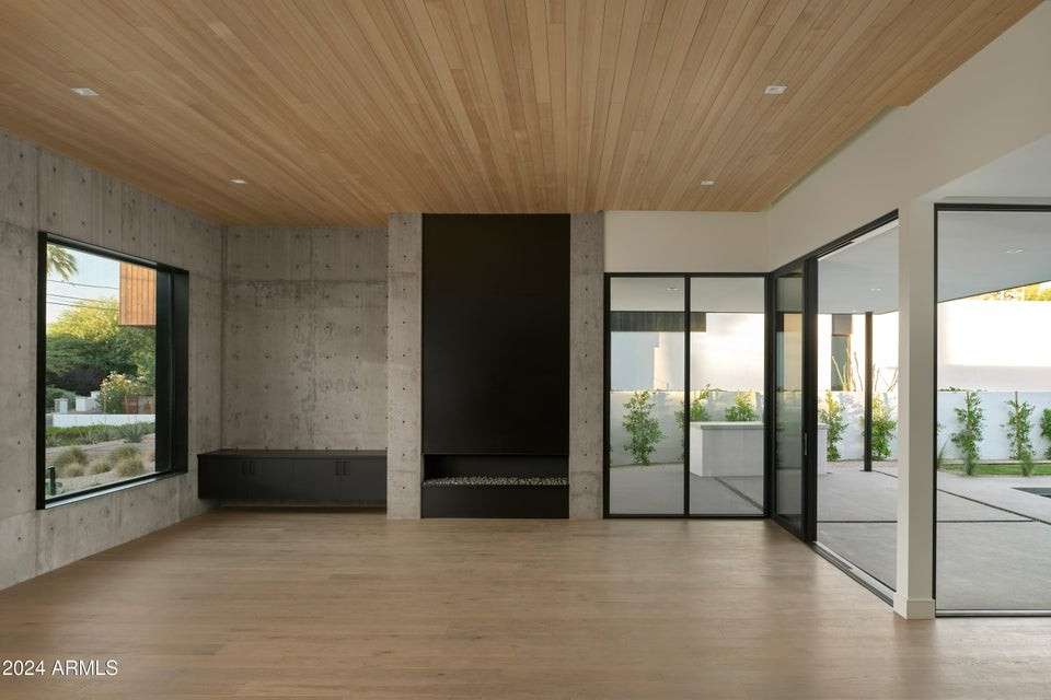 12 of 27. Showcasing a striking mix of textures, this light-filled living space features warm wood ceilings, expansive windows, and clean architectural lines designed for comfort and visual impact.
