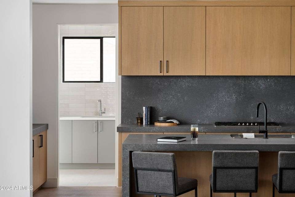 17 of 27. With bar-style seating, a matte black faucet, and designer finishes, this spacious kitchen invites both casual breakfasts and elevated dinner parties in style.